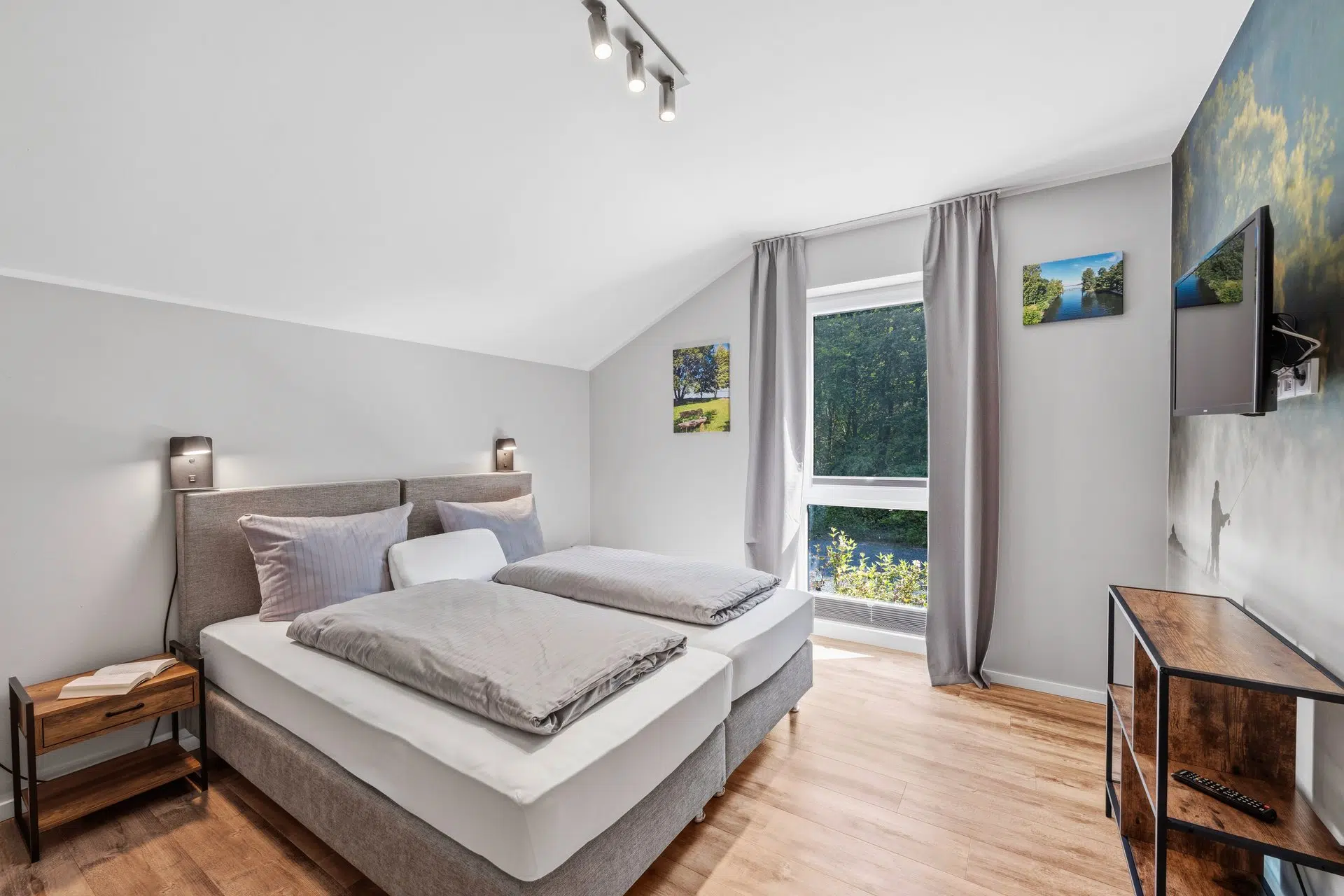 Dachschlafzimmer mit Waldbildern und Balkonzugang