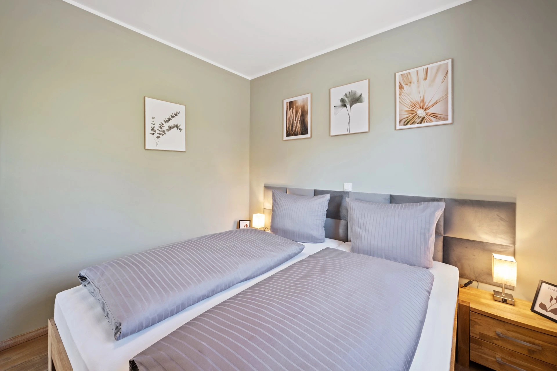 Schlafzimmer mit Doppelbett und gerahmten Bildern