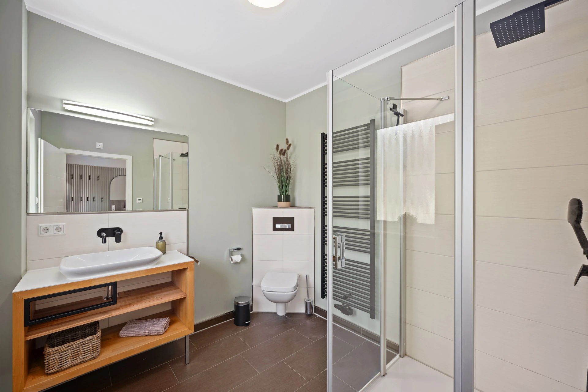 Badezimmer mit Glasdusche und Handtuchheizung