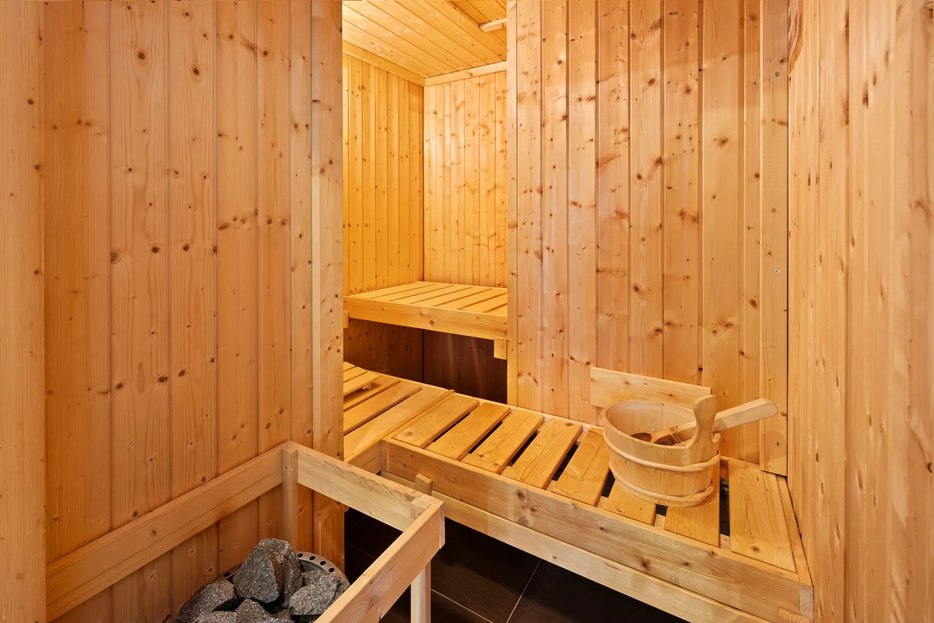 Sauna mit Holzbänken und Aufgusskübel