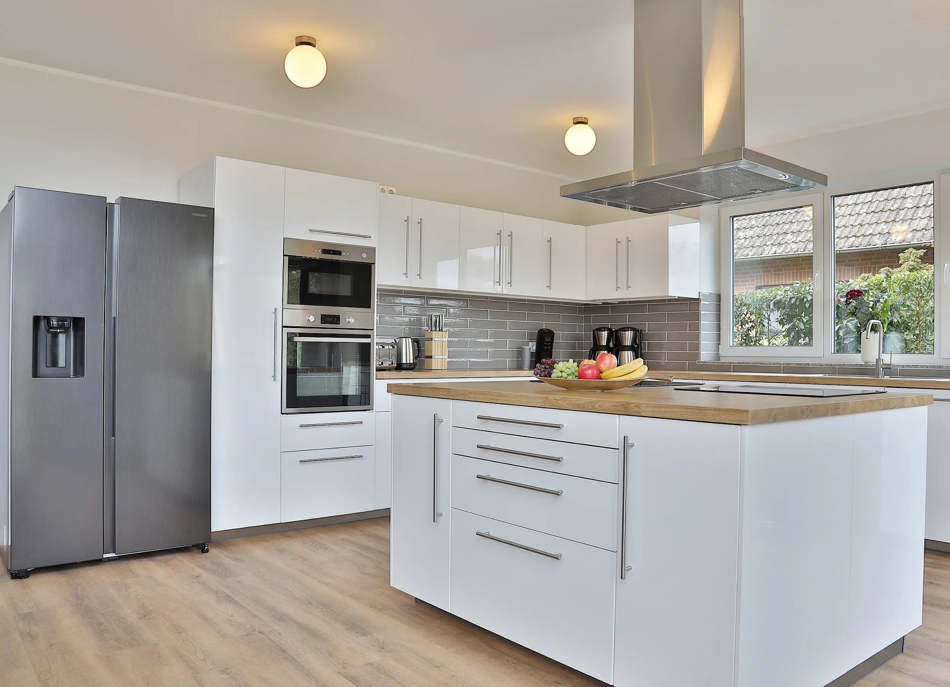 Küche mit Kochinsel und freistehendem Kühlschrank