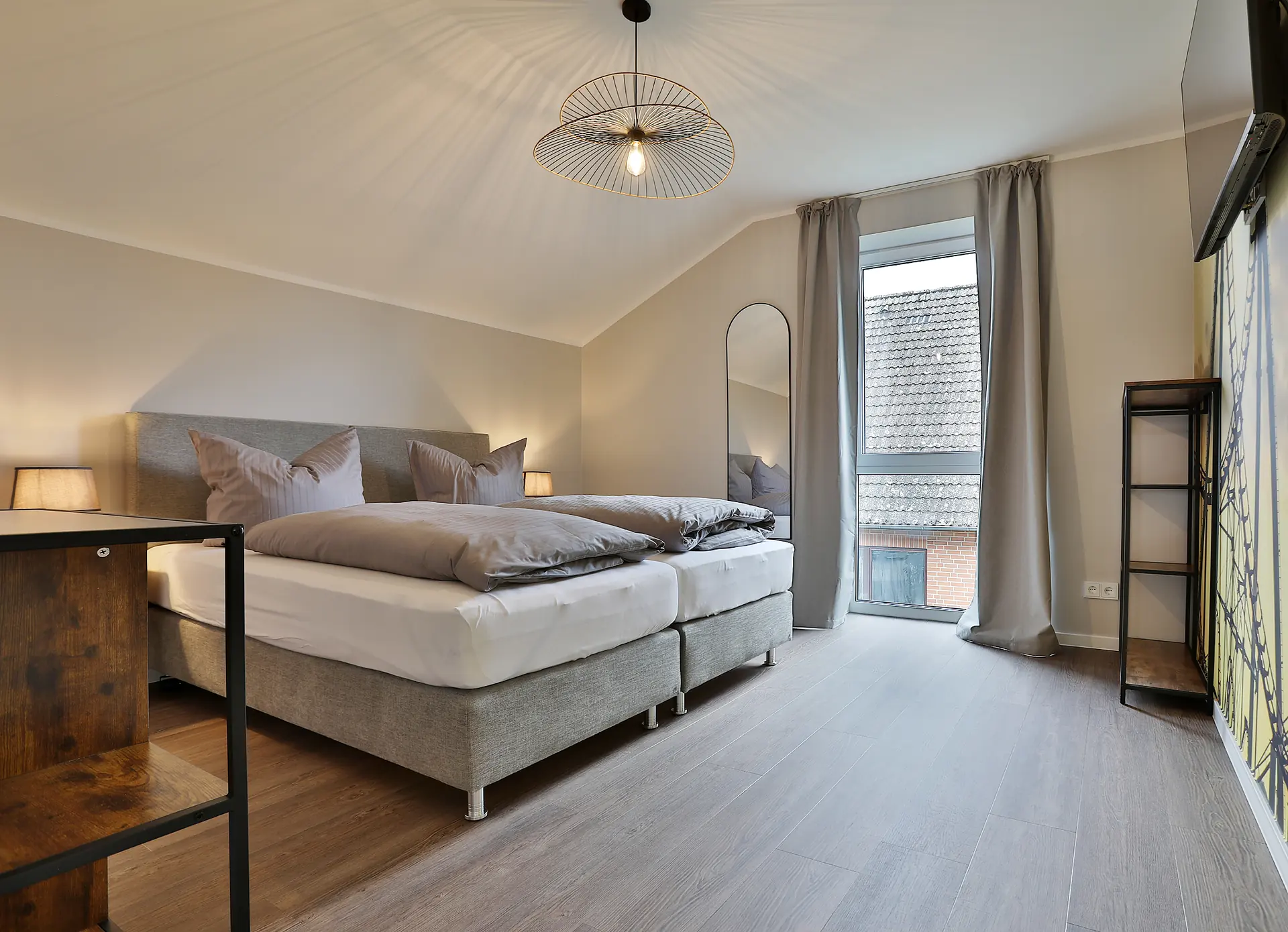 Schlafzimmer mit Schreibtisch und rundem Wandspiegel
