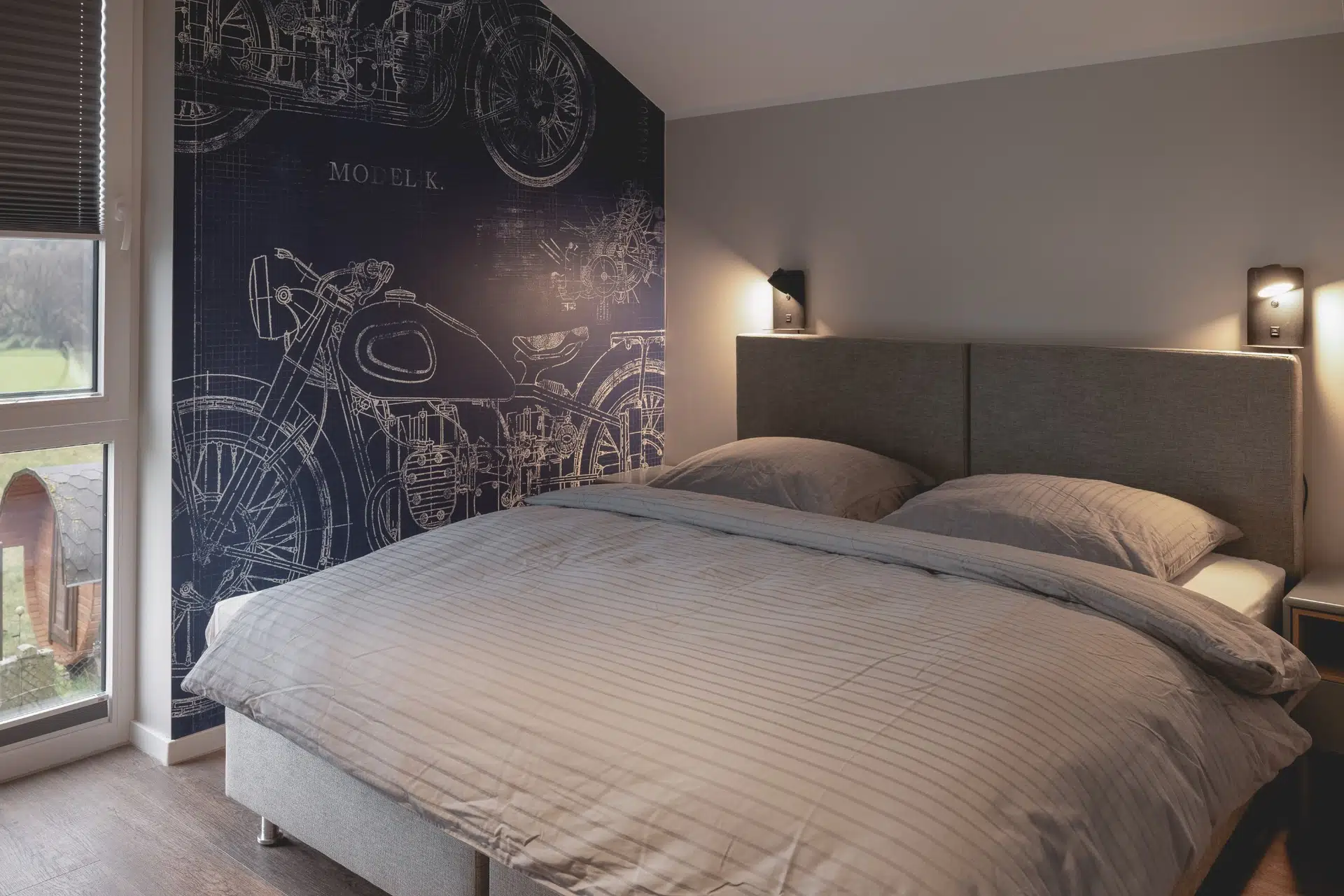 Schlafzimmer mit Motorrad-Wandbild und Terrassenzugang