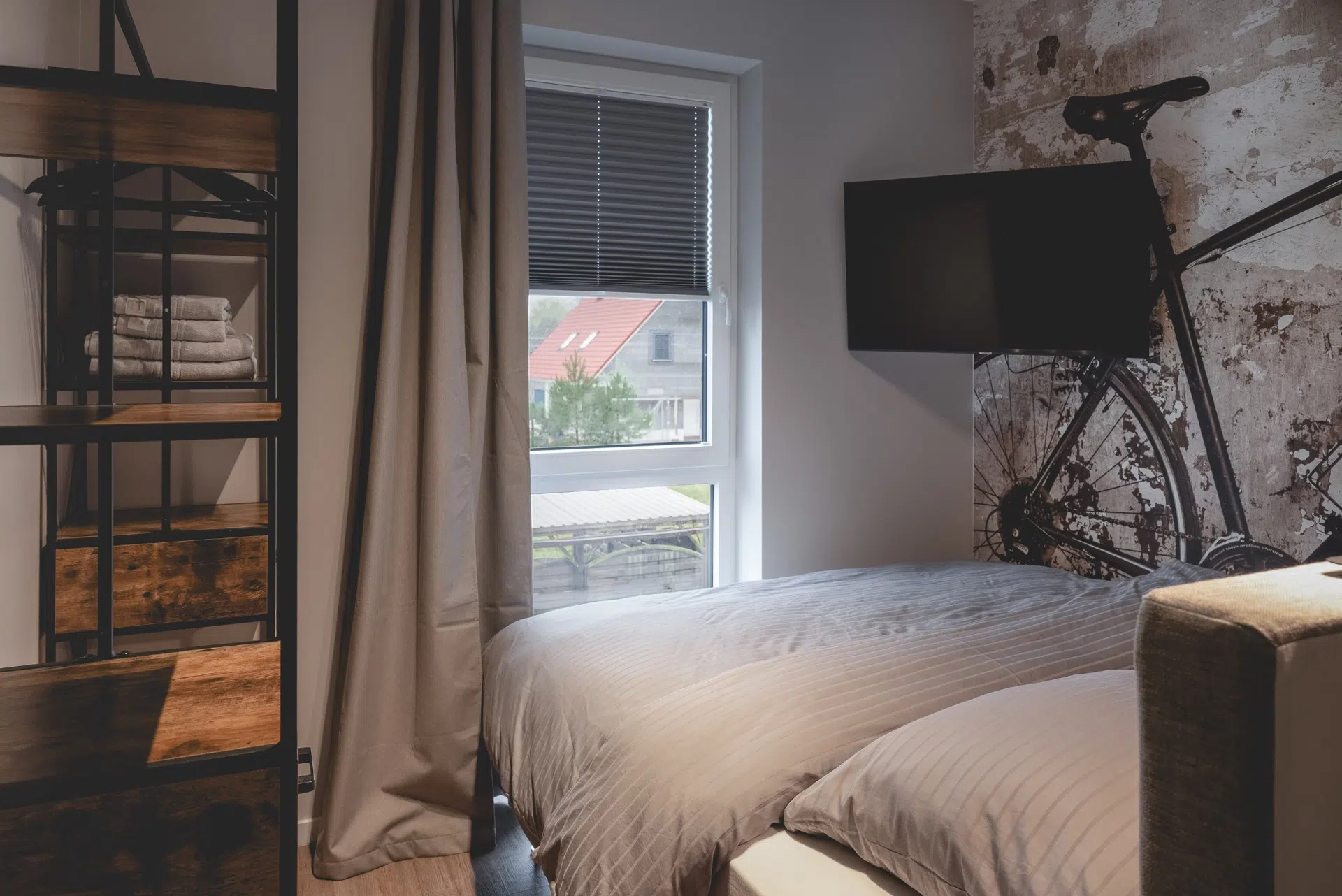 Schlafzimmer mit Fahrrad-Wandbild und offenem Regal