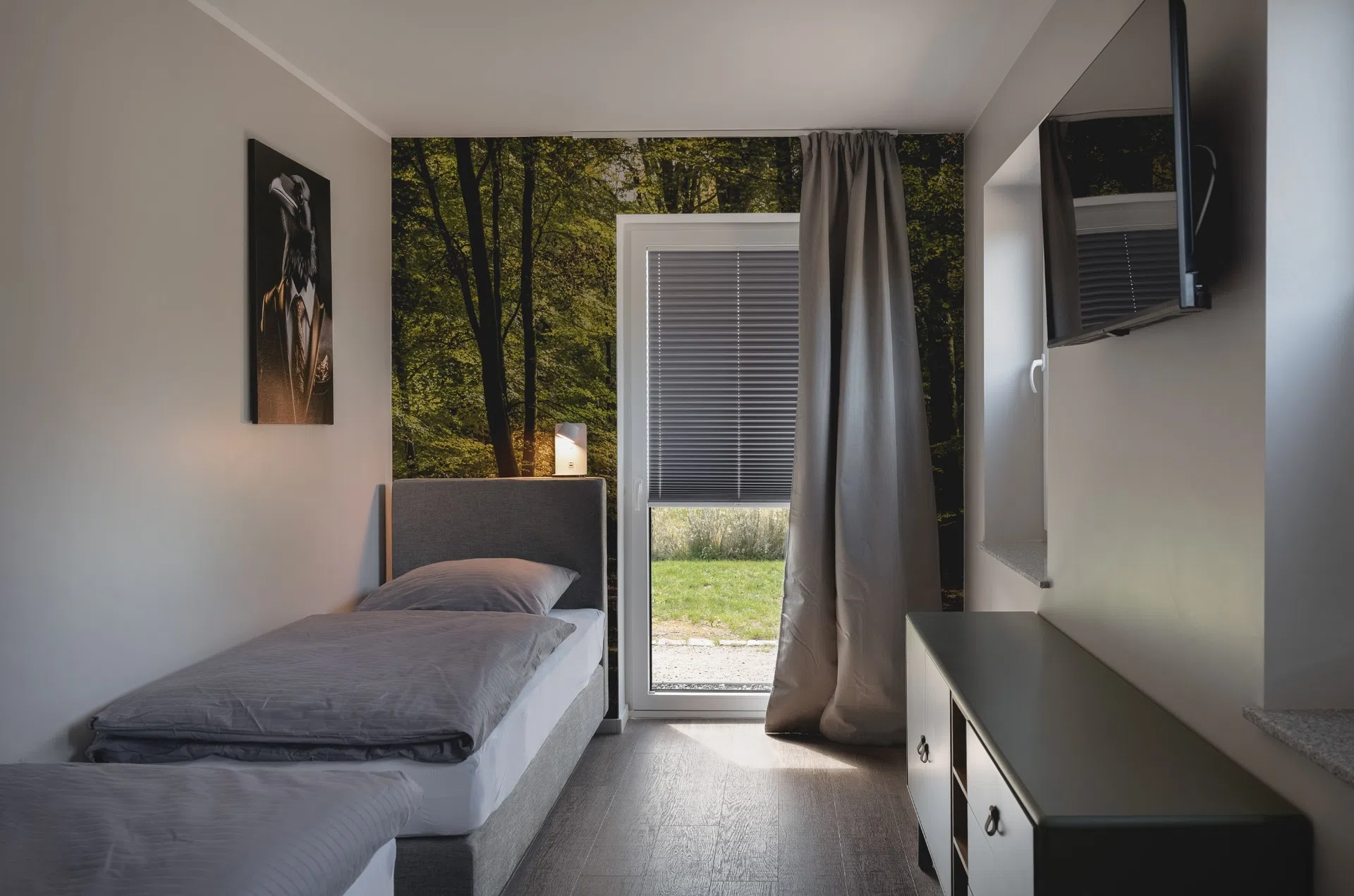 Einzelbett vor Wald-Wandbild mit Terrassenzugang