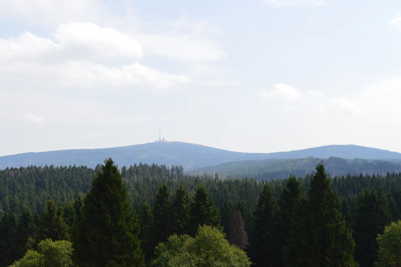 Blick über die bewaldeten Hügel des Oberharz mit dem Brocken im Hintergrund