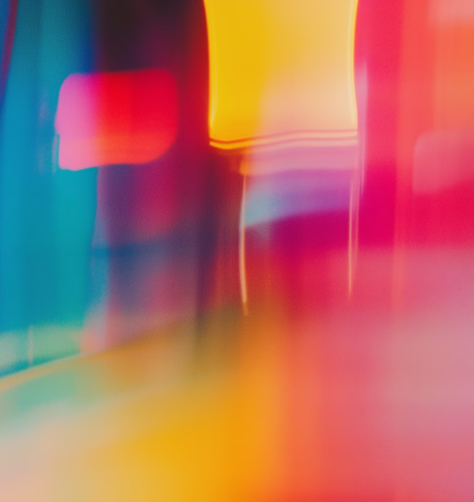 Abstract blurred background with vertical streaks of vibrant colors including red, yellow, pink, purple, and blue.