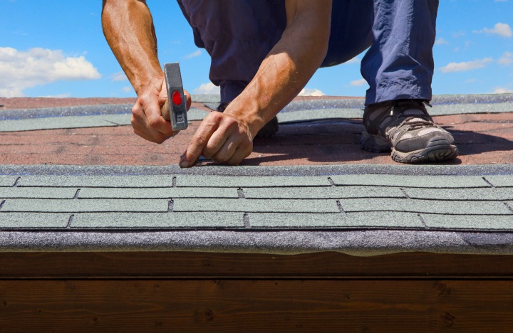 Man installing asphalt shingles