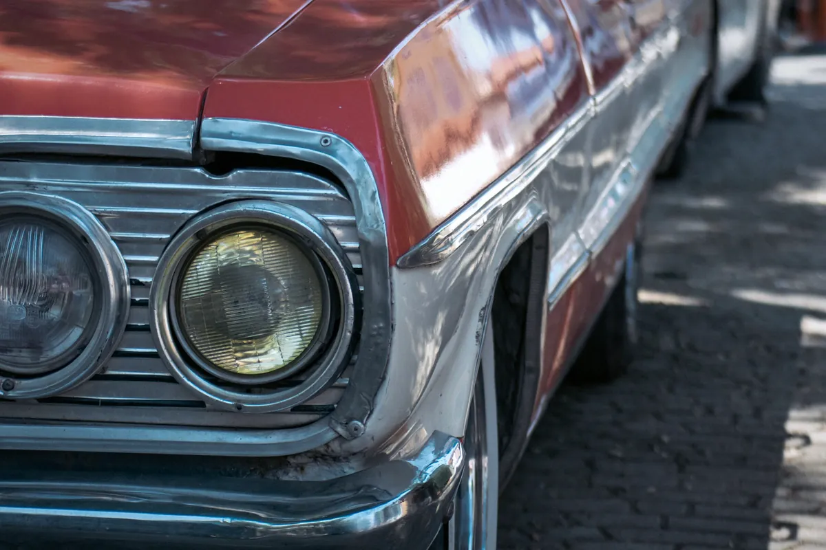Chrom-Frontpartie mit Rundscheinwerfer eines Chevrolet-Klassikers für eine Oldtimer-Bewertung in Kiel