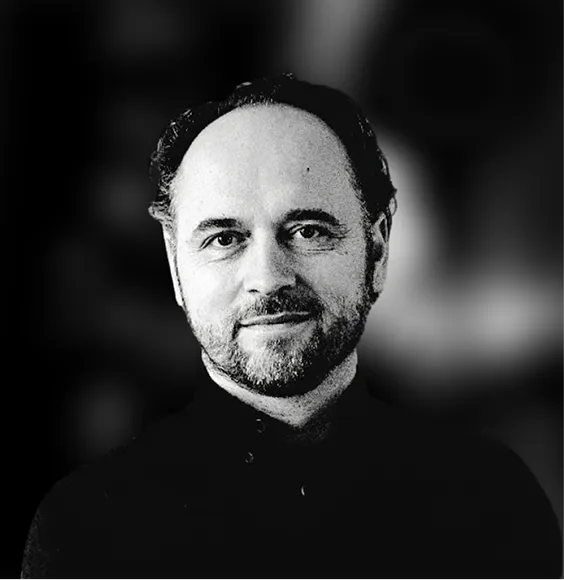 Black and white portrait of a smiling middle-aged man with short hair and a beard.