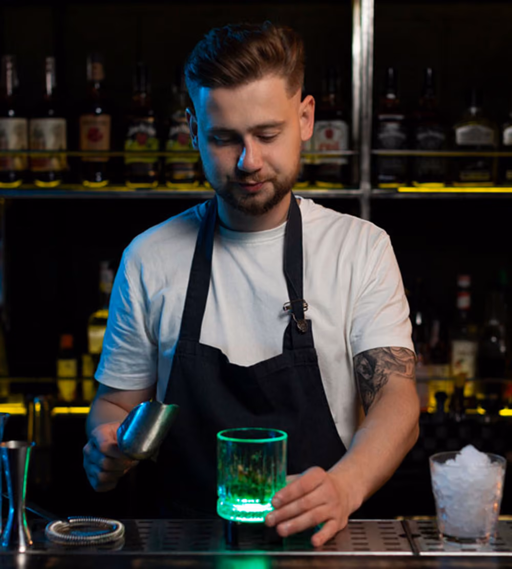 Barman preparando un cóctel en la barra