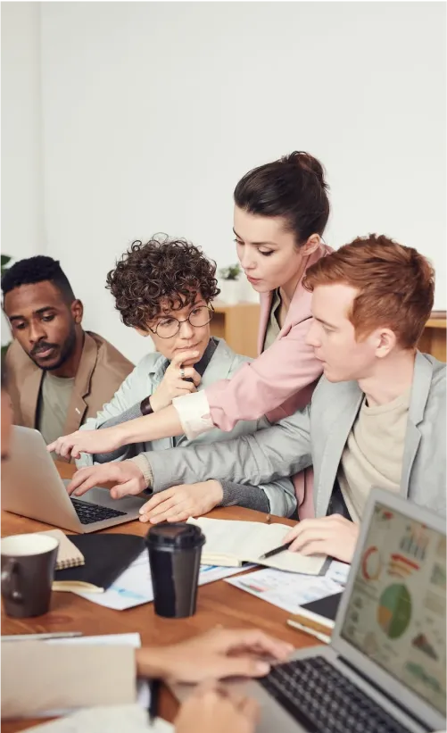 IT team collaborating on laptops during a data review session