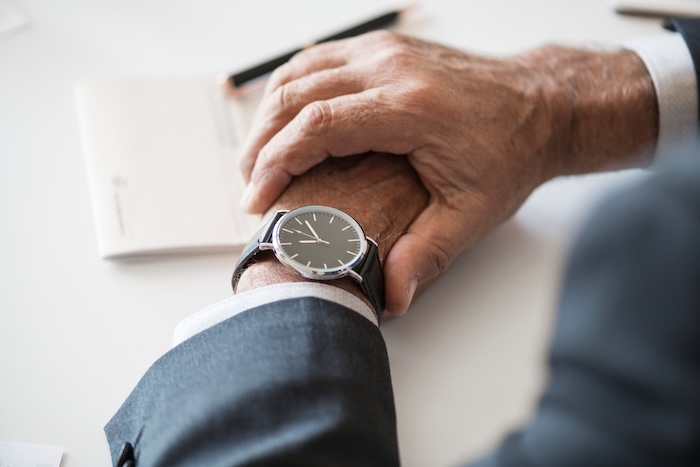 Executive checking the time, representing delays in IT projects