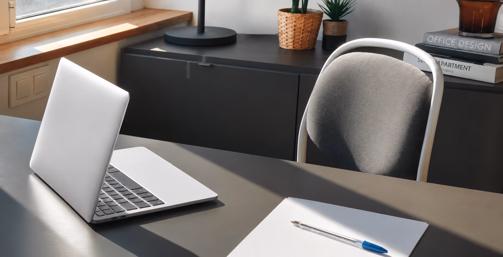 Desk with an open laptop and papers in a quiet office