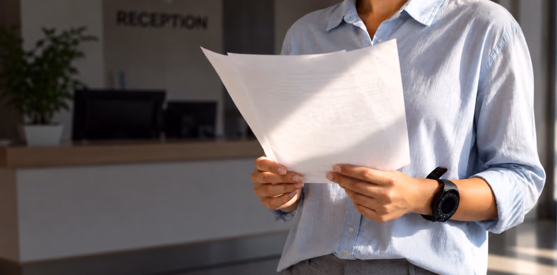 Person reading a hospital bill in a reception area
