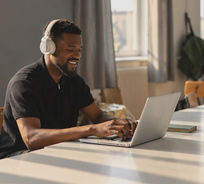 A man with headphones working on a laptop