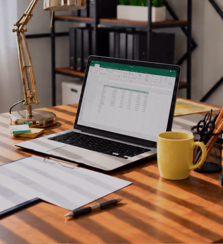Hands typing on a laptop showing a claims spreadsheet