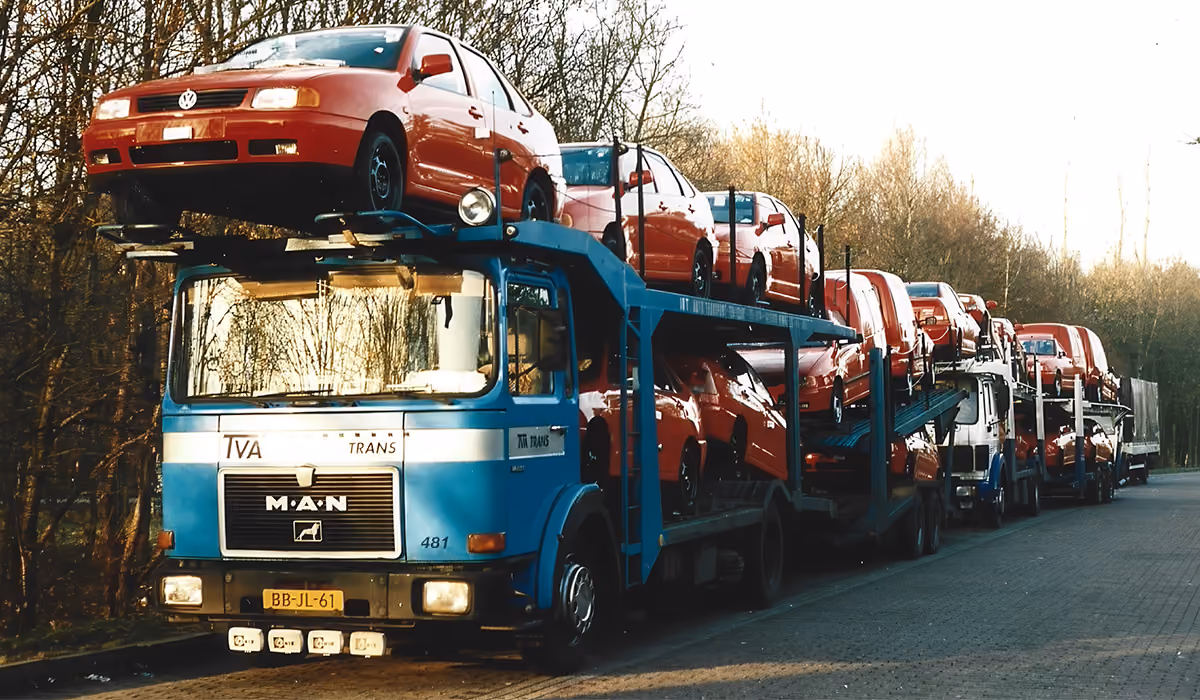 Historische foto van een TVA Trans vrachtwagen geladen met rode auto's