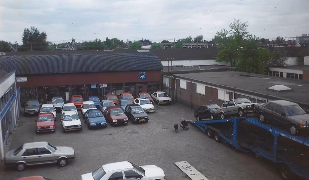 Historische luchtfoto van het voorraadterrein van Ten Velde met occasions en een transportwagen