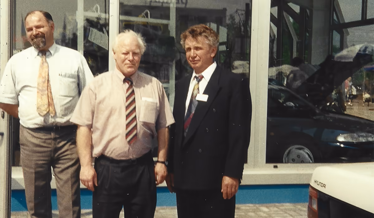 Historische foto van drie mannen voor de showroom van Ten Velde