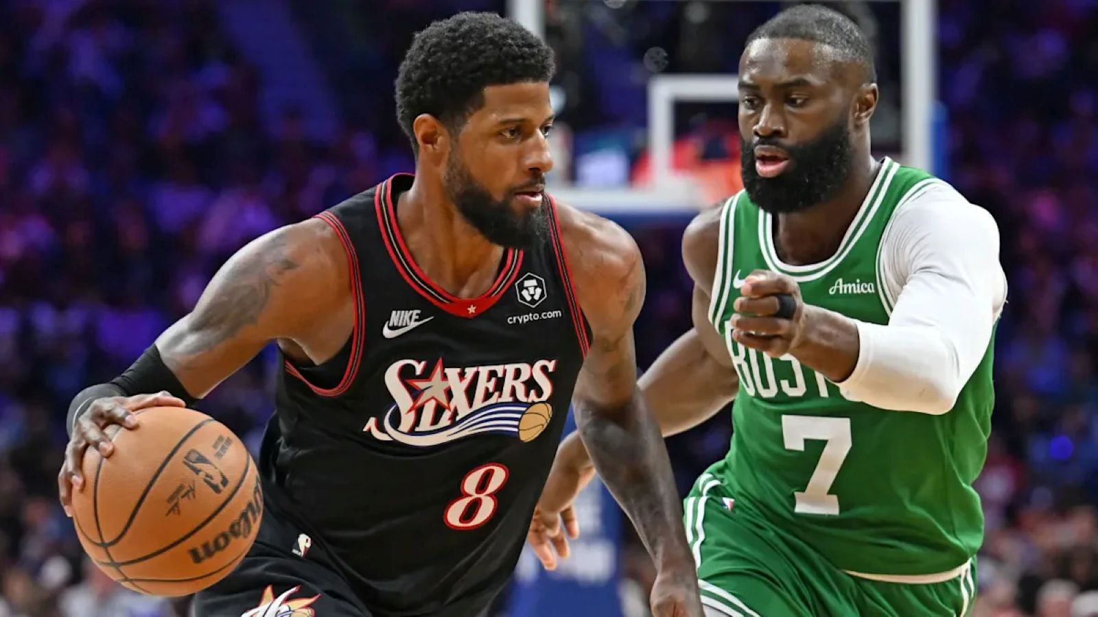 Paul George, in a black Philadelphia 76ers jersey with the number 8, drives with the ball as Jaylen Brown, in a green Boston Celtics number 7 jersey, defends.