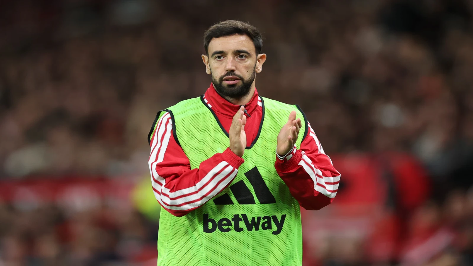 Bruno Fernandes applauds supporters during a Manchester United warm-up.