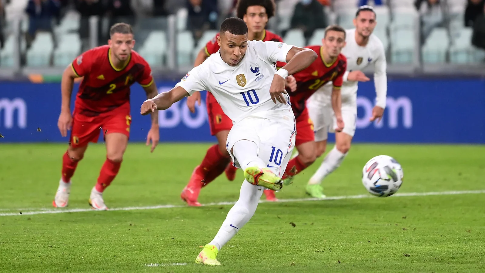 Kylian Mbappé shoots for France as Belgium defenders look on during the 2021 UEFA Nations League semi-final.