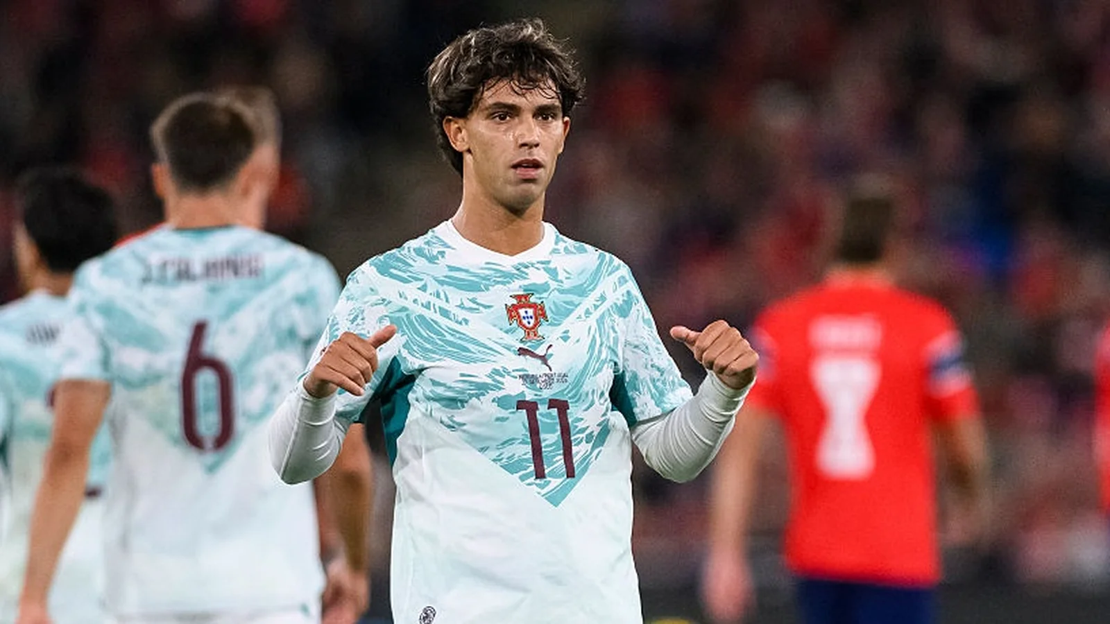 João Félix wearing Portugal’s national team shirt during a match, with teammates in the background.