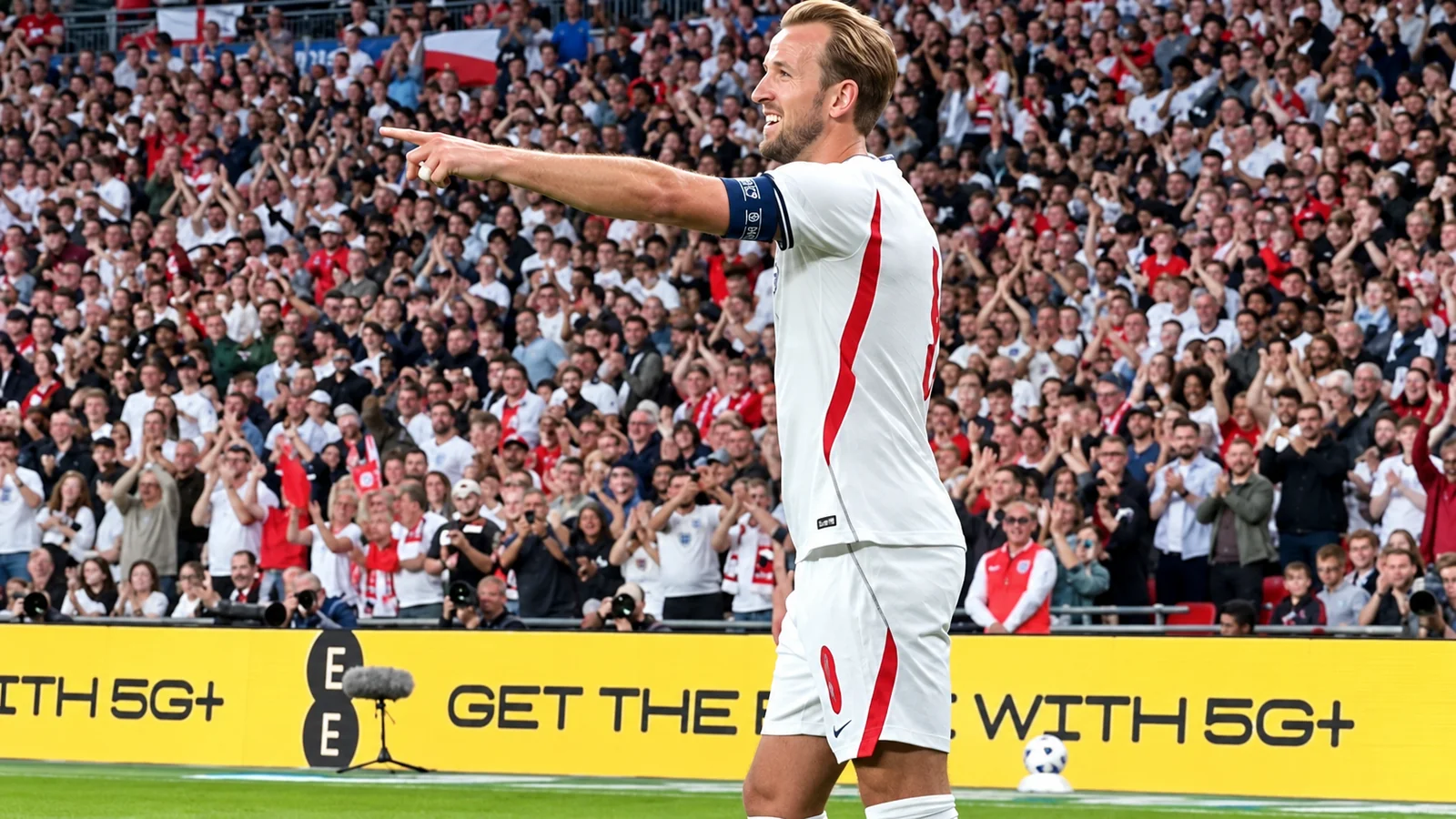 Harry Kane points toward the crowd while celebrating for England in front of cheering supporters at Wembley.