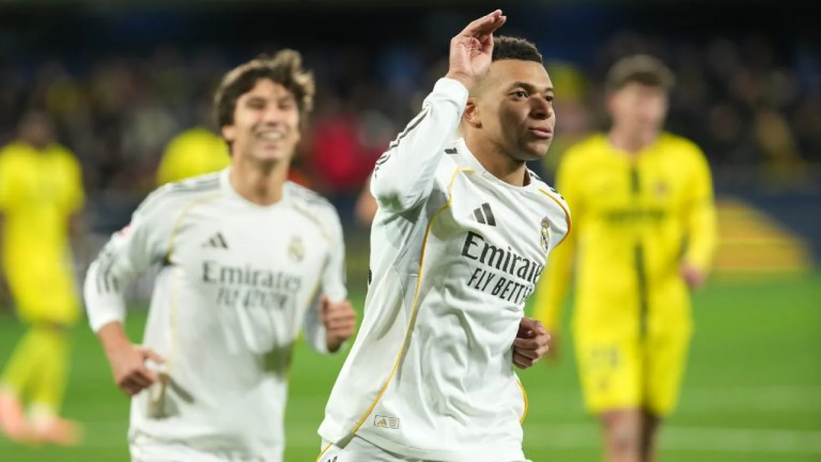 Kylian Mbappé celebrates for Real Madrid during a match as a teammate runs behind him.
