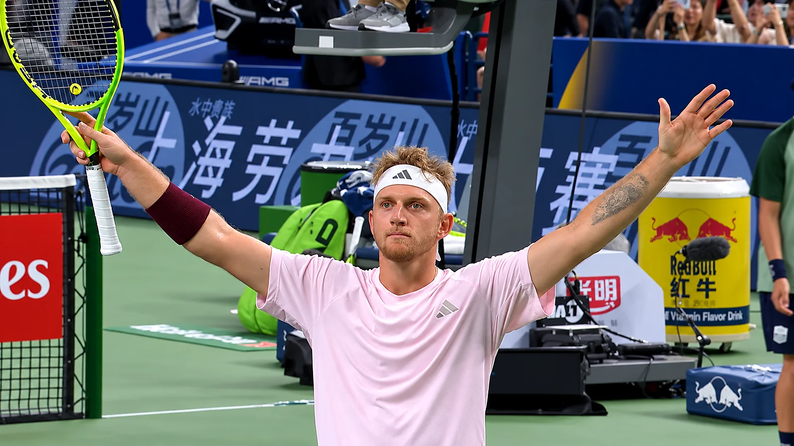 Tennis player celebrates on court with both arms raised after a match at the Shanghai Masters.