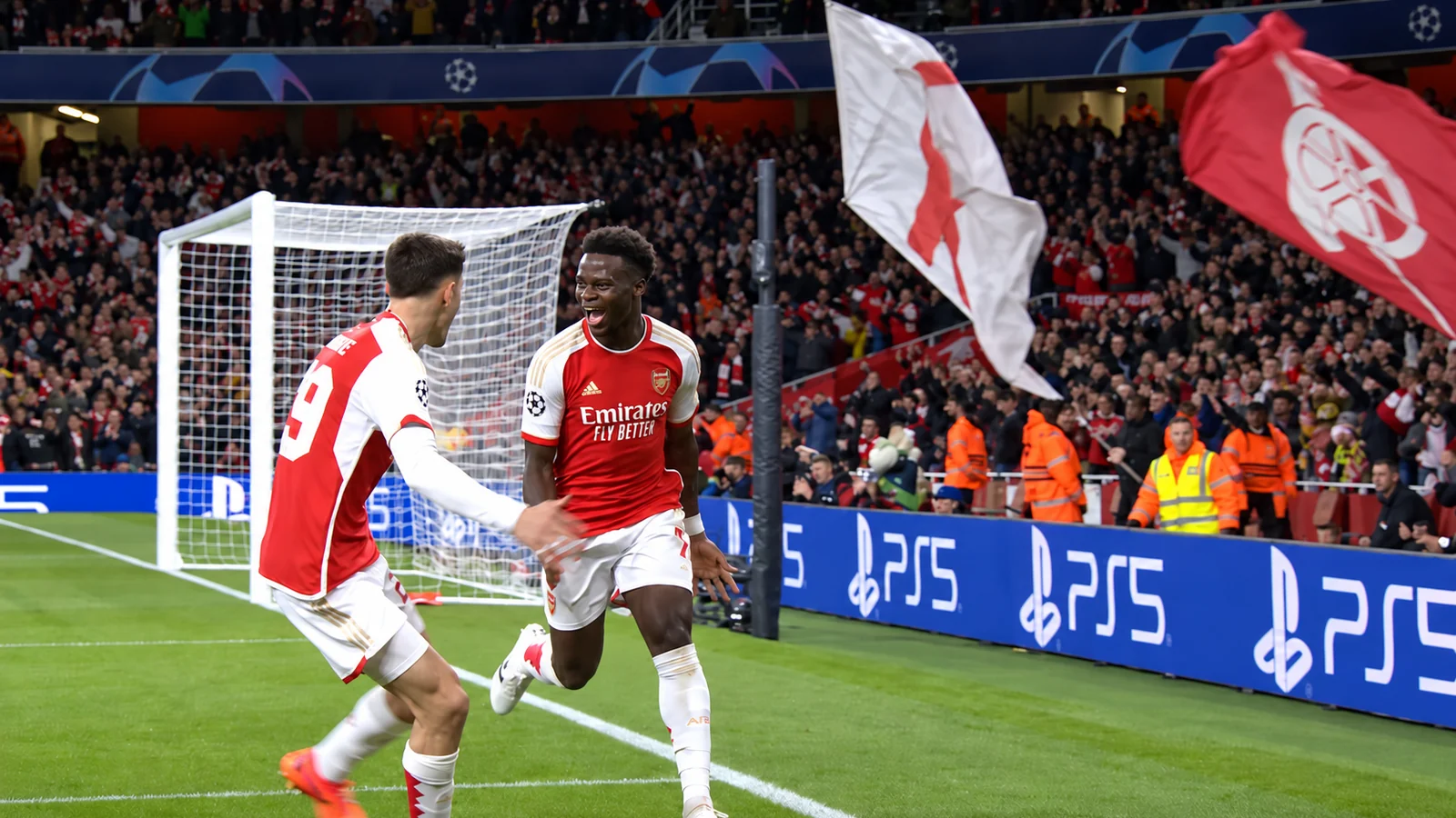 Arsenal players celebrate near the corner flag during a Champions League match at the Emirates Stadium.