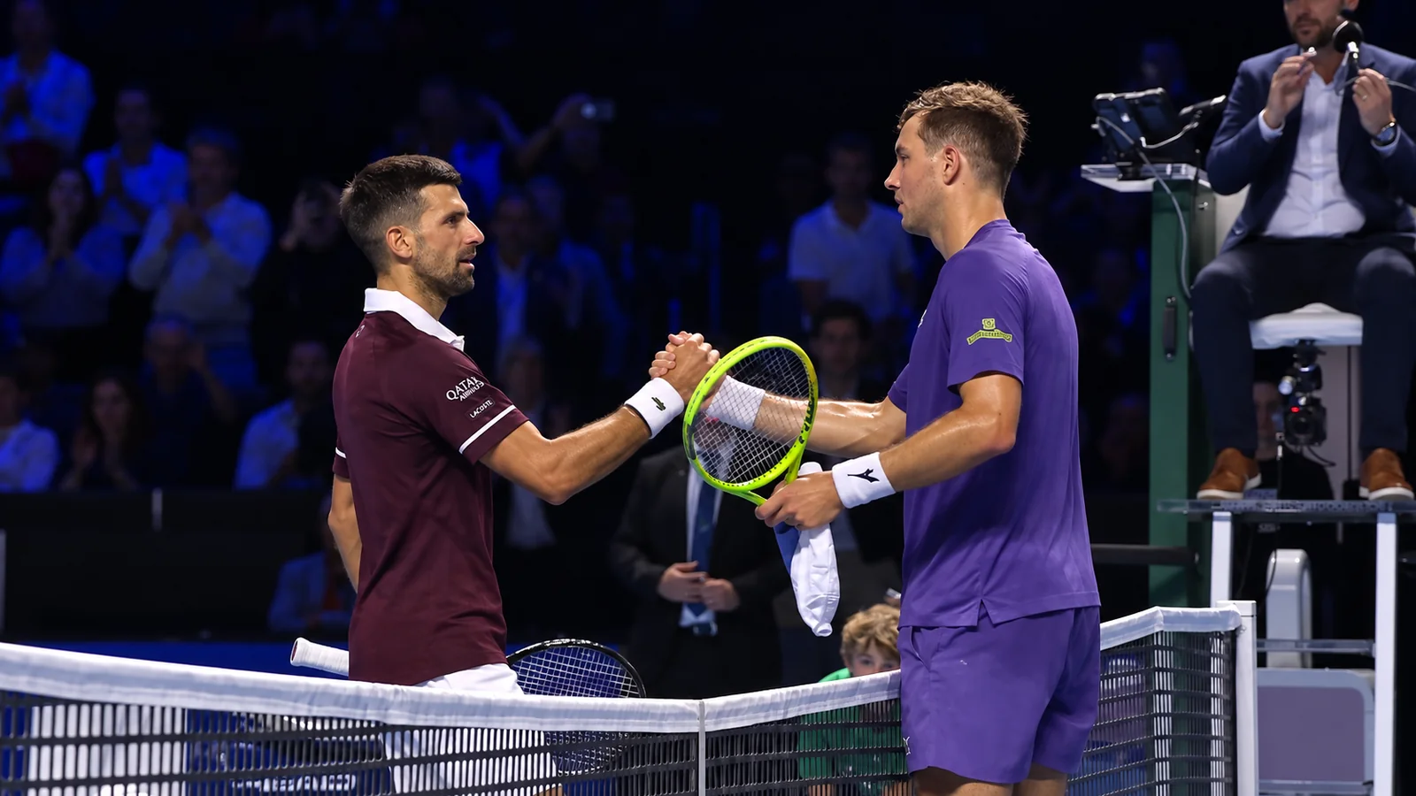 Novak Djokovic shakes hands with his opponent at the net after their match.