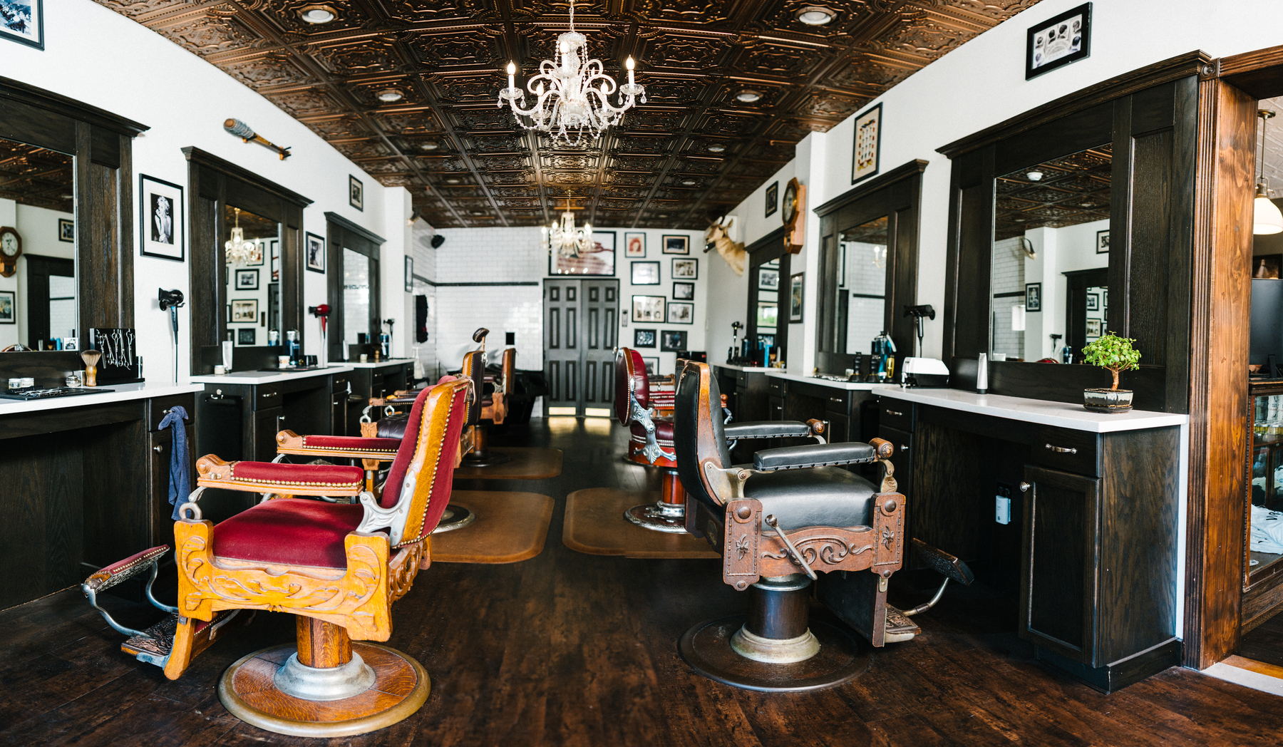 The barber floor at The Stray Hare, with antique chairs under a pressed tin ceiling