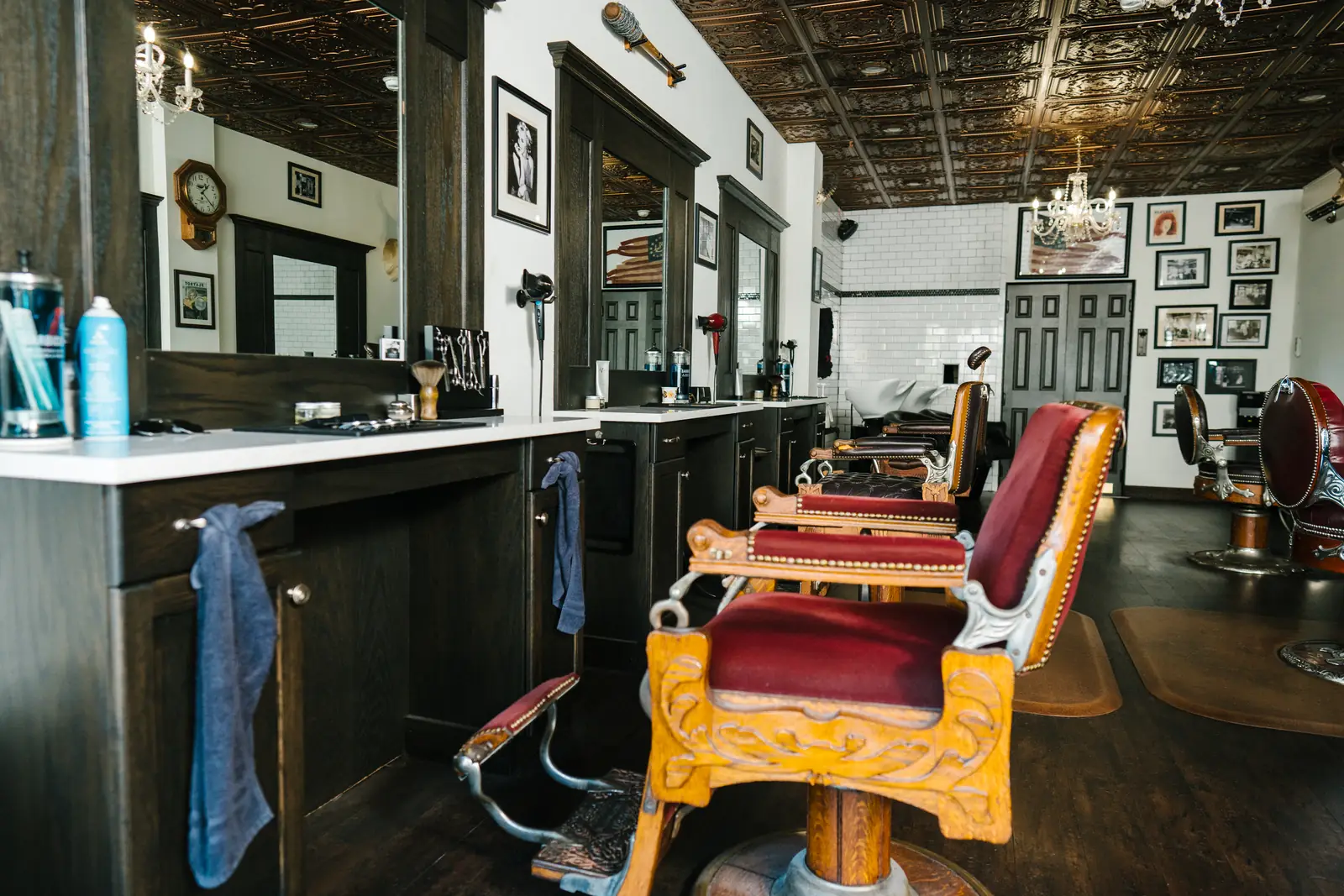 Antique barber chairs and mirrored stations under the pressed tin ceiling at The Stray Hare