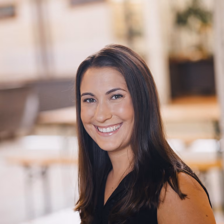 Kristen Wile, founder of Unpretentious Palate, smiling in a professional setting, showcasing her dedication to Charlotte’s culinary scene.