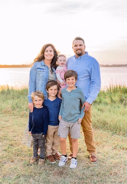 Trey Schnippel with his wife, Maureen, and their four children, smiling together outdoors.