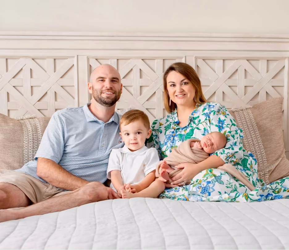 Daniel Hudspeth, CFP®, with his wife, Kara, and their two sons, Mac (3) and Carson (6 months), smiling together in their Riverwalk home.
