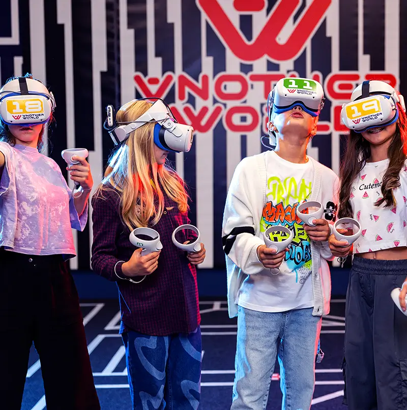 A group of children in VR headsets celebrating at the arena