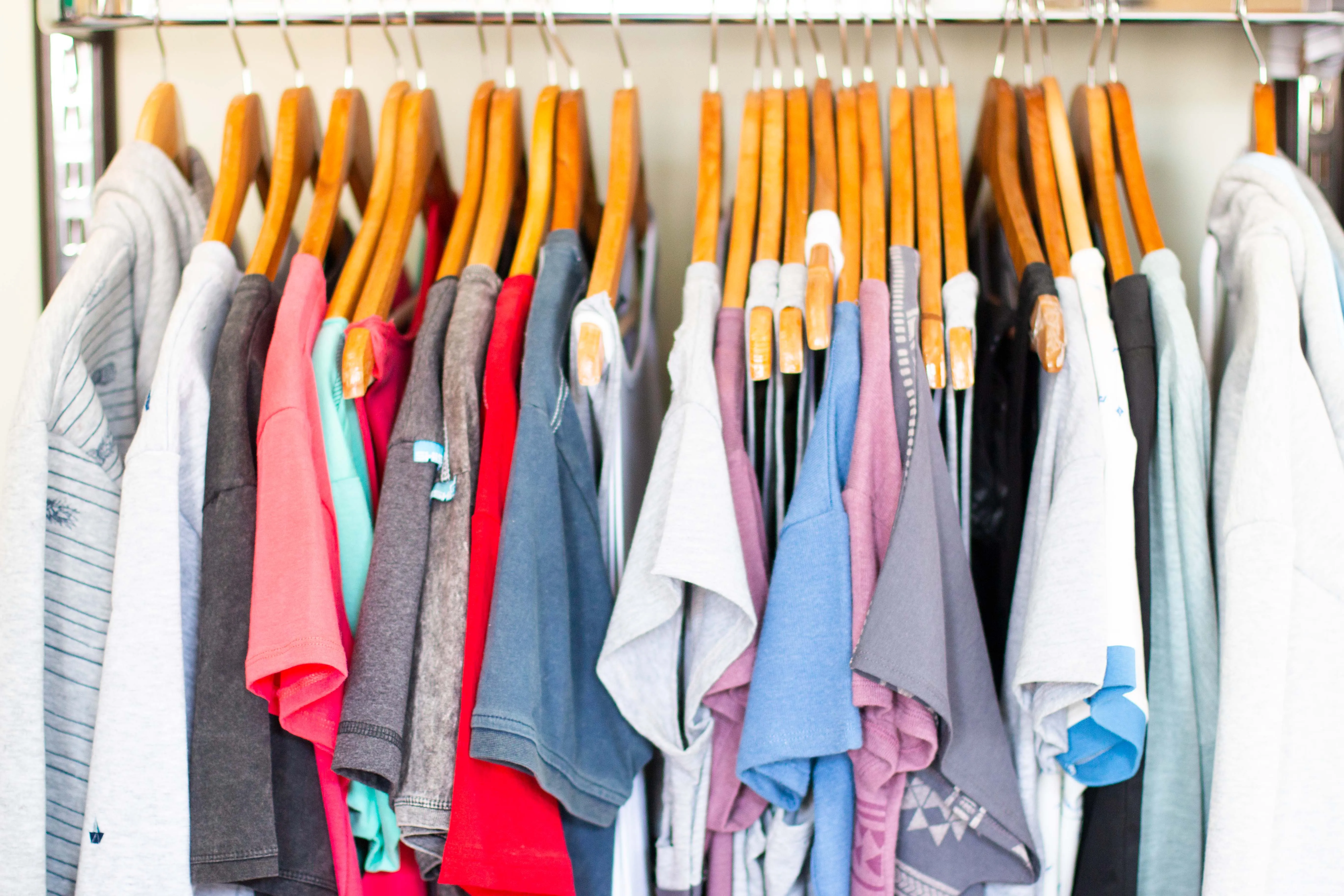 Shirts und Sweatshirts in vielen Farben auf Holzbügeln an einer Kleiderstange in der Türkei
