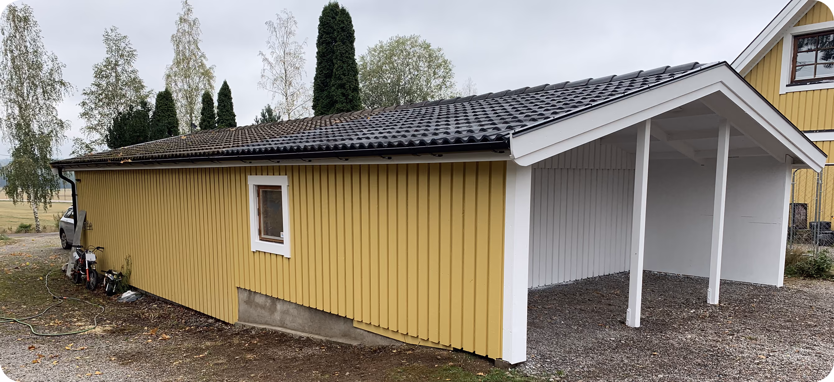 Byggnation av gul carport med tak för bil i Stockholm, utfört av IVAB BYGG & Renovering AB.