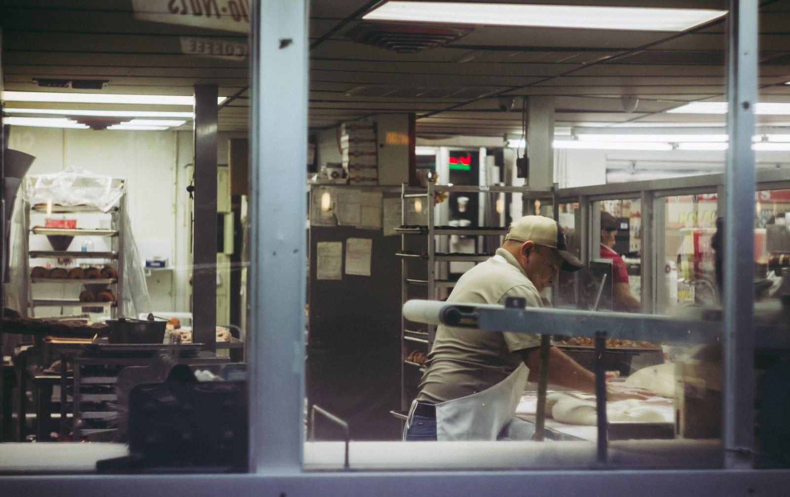 A baker working dough by hand in a commercial kitchen