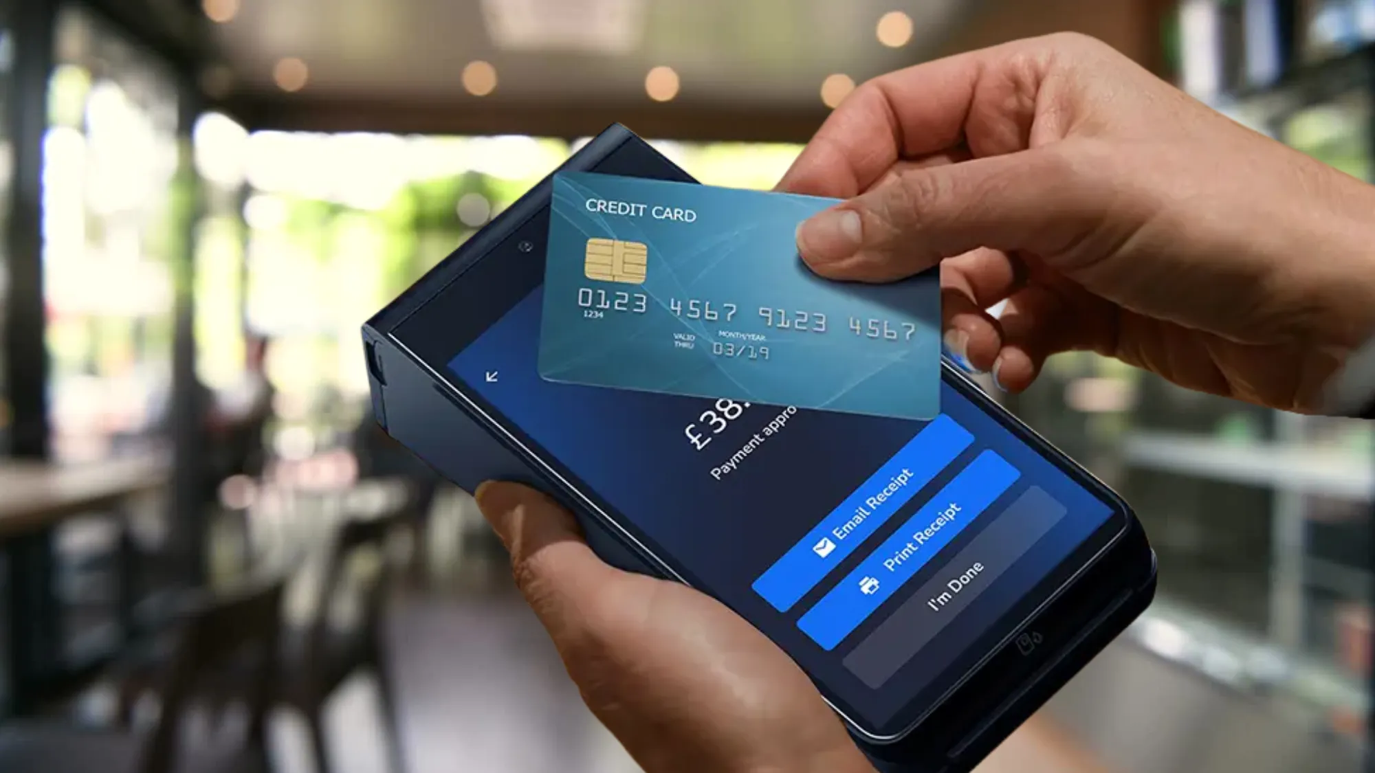 Contactless card held over a Shift4 card machine showing payment approved