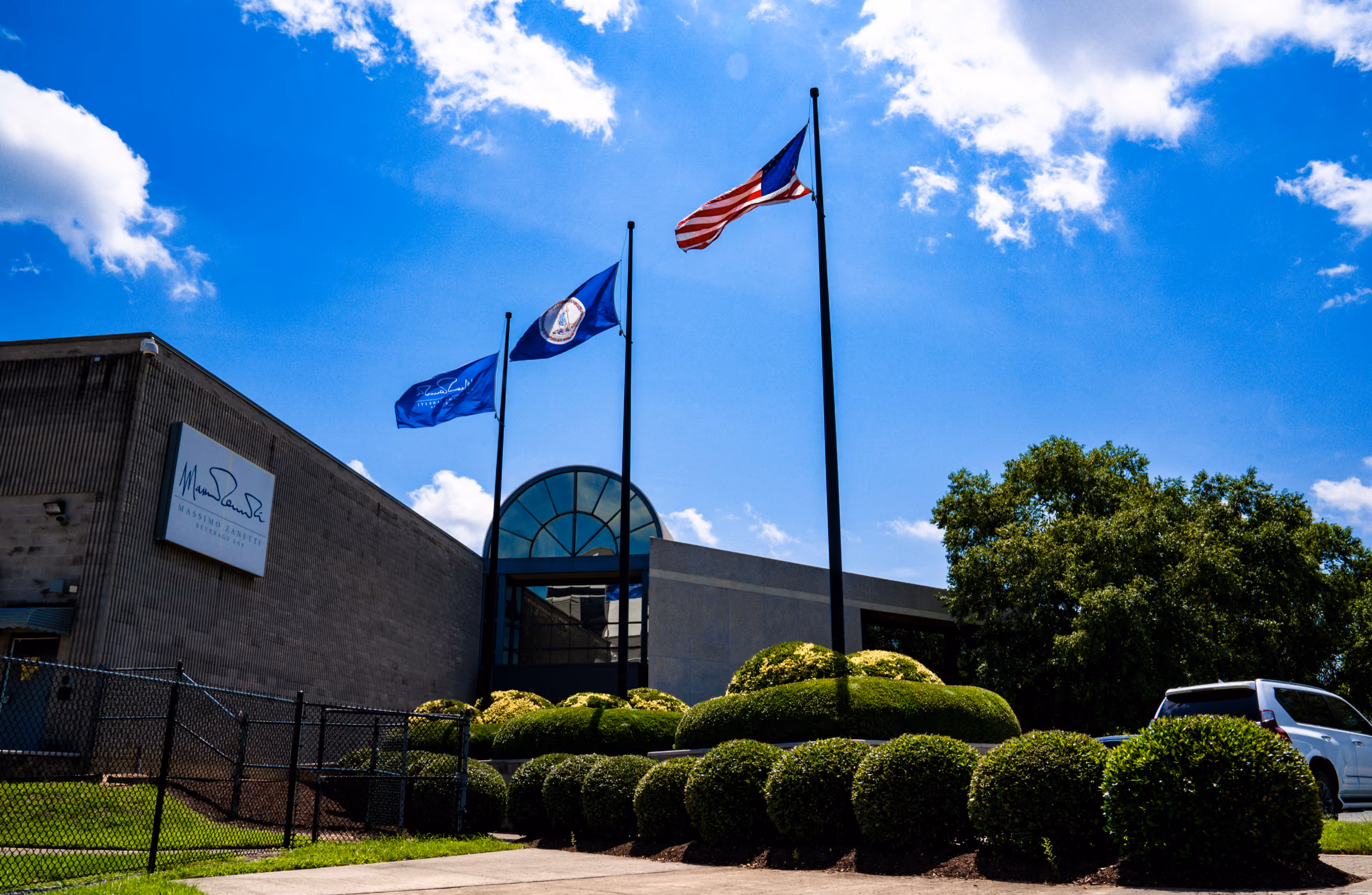 The Massimo Zanetti Beverage USA headquarters in Suffolk, Virginia, with flags flying at the entrance