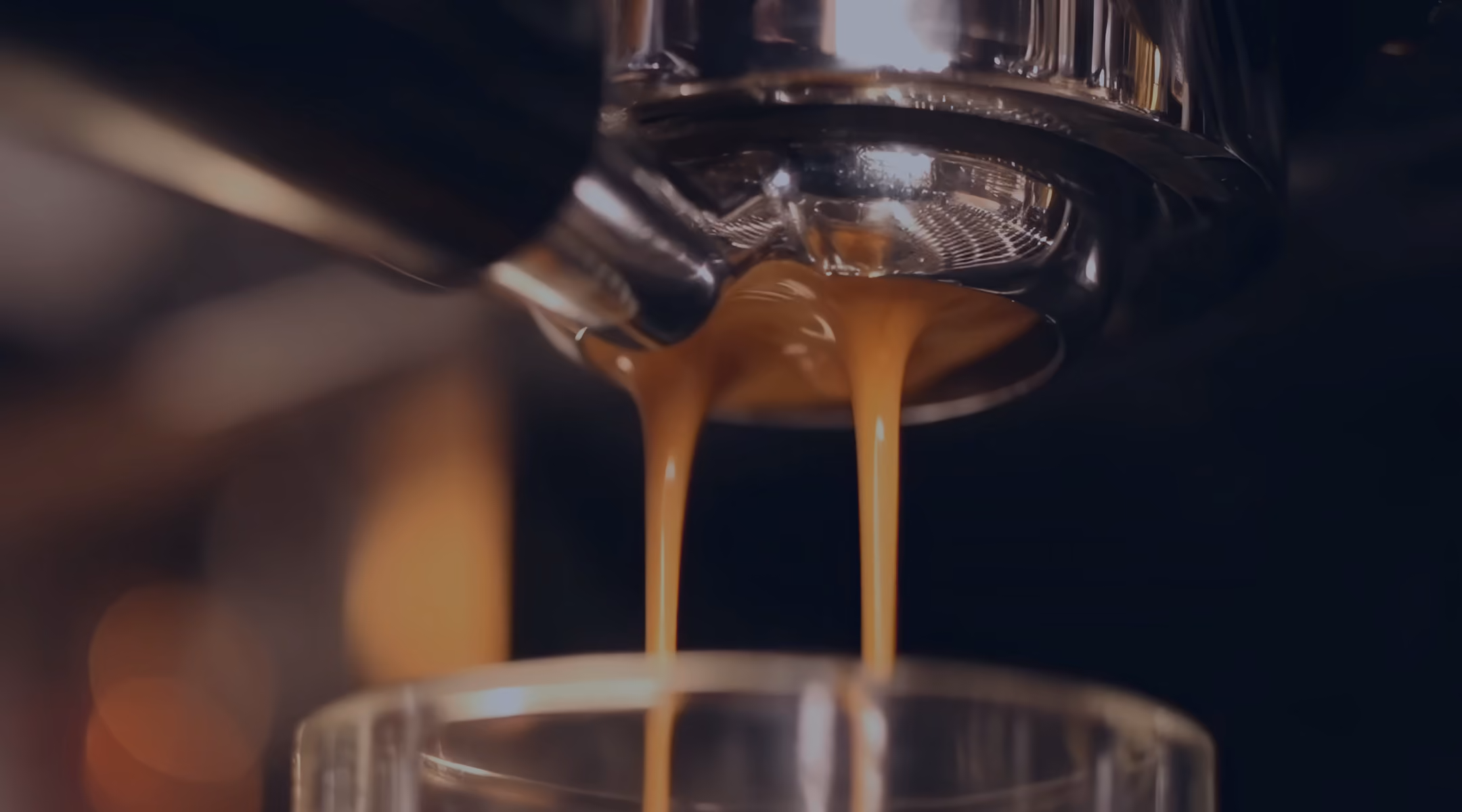 A Segafredo coffee bag and espresso cup on a marble bar beside a professional espresso machine