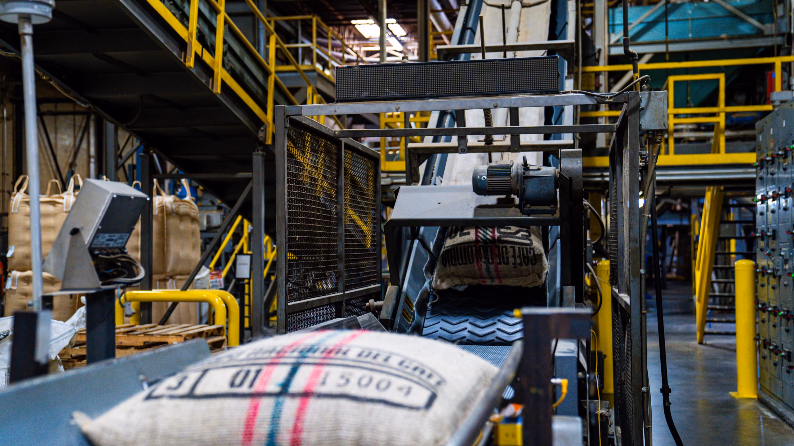 Burlap coffee sacks on a conveyor inside the MZB roasting facility