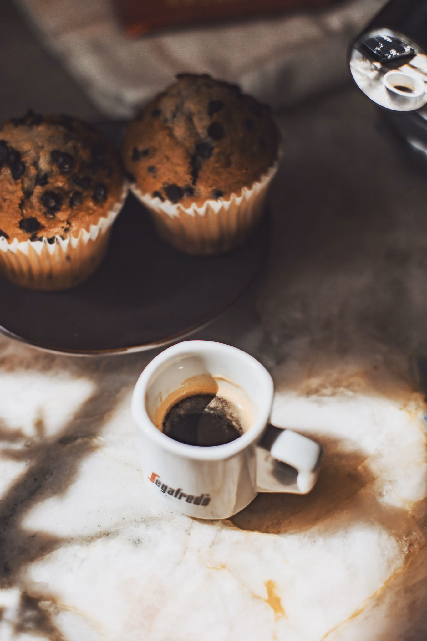 A Segafredo espresso and a pastry on a cafe table