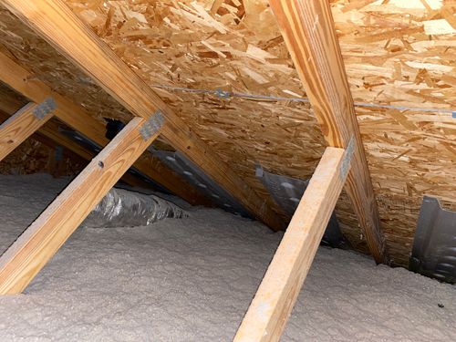 Armor Roofing attic inspection showing roof decking, trusses, insulation, and ventilation baffles