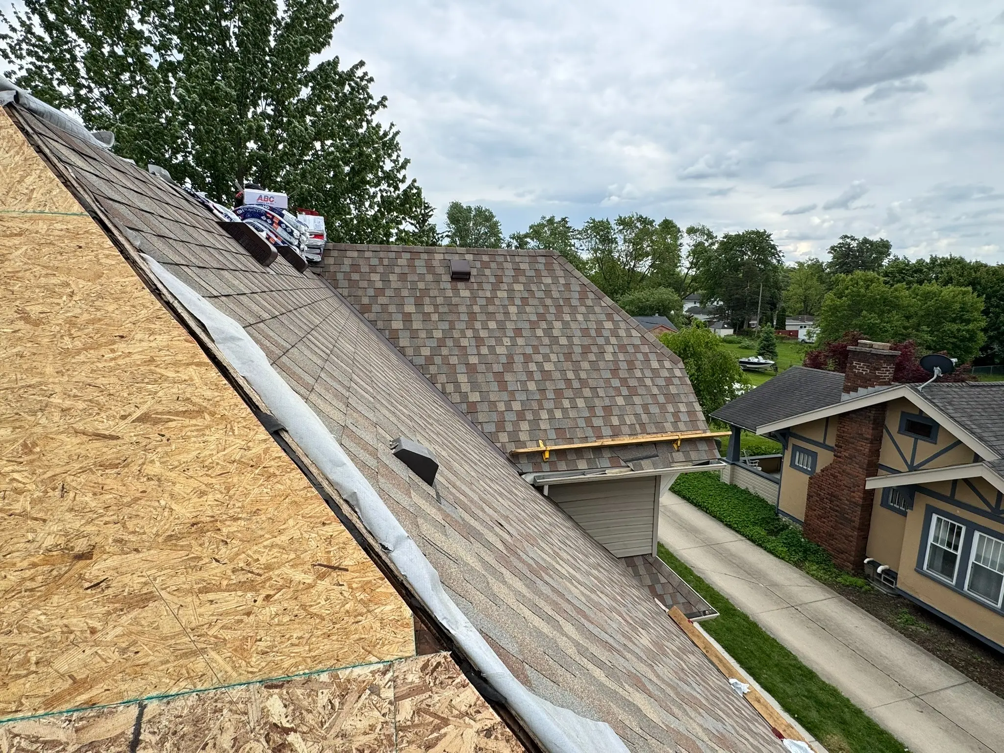 Roof replacement in progress showing exposed deck and deck-protection installation