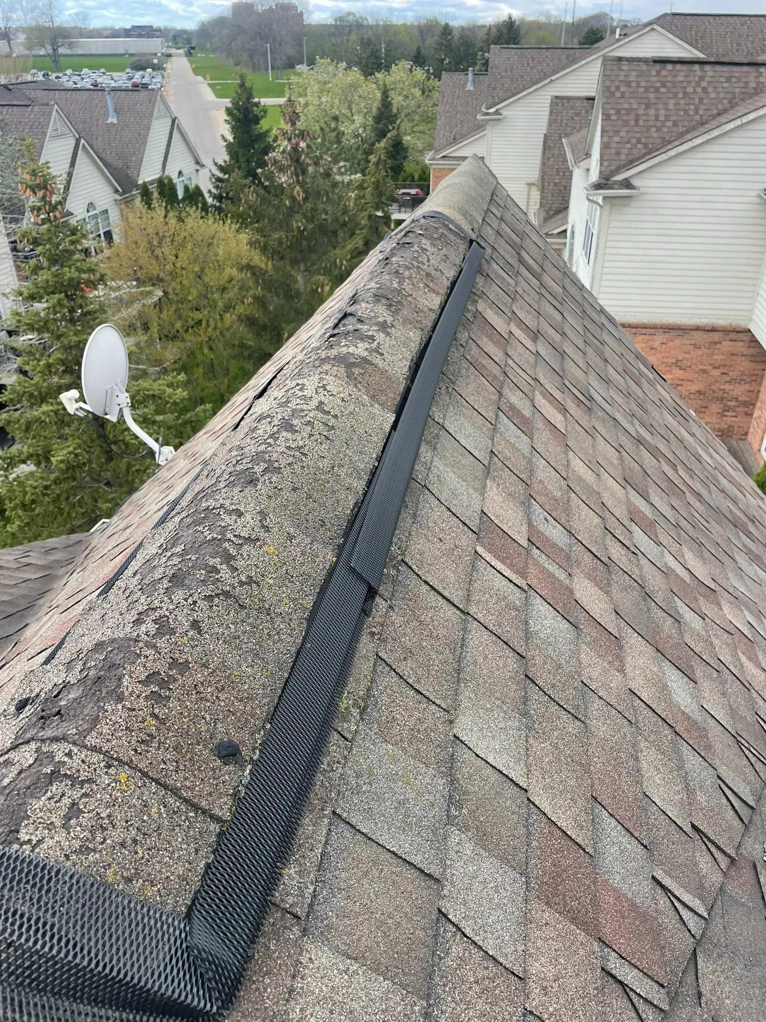 Storm-damaged and deteriorated ridge cap shingles documented during an Armor Roofing inspection